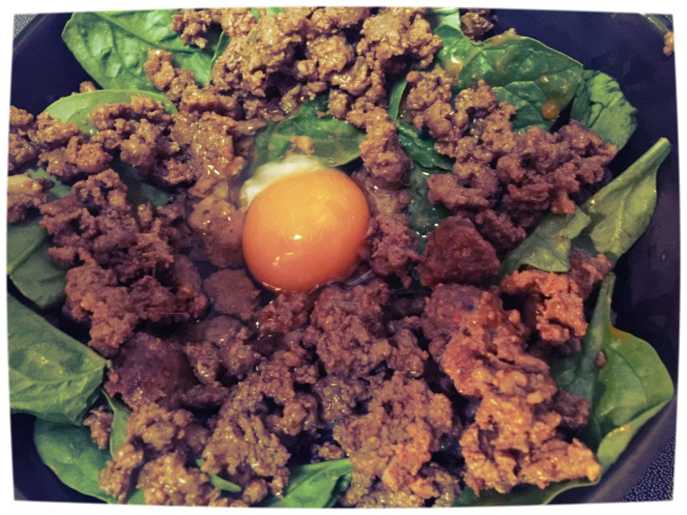 Beef chorizo sausage minced on bed of spinach with poached egg on top