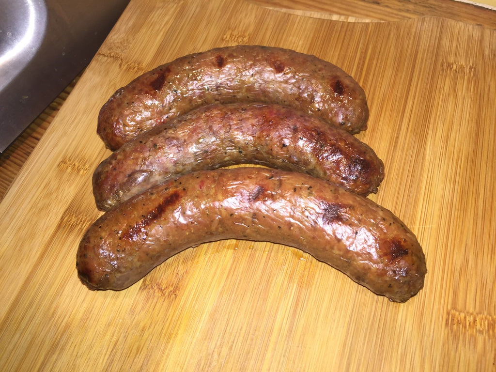 Photo of 3 cooked sausage links on a wood cutting board